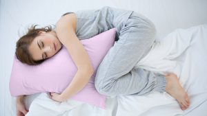 Donna che dorme con un cuscino tra le gambe