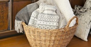 cesto di vimini con coperte di lana, una delle idee camera da letto di tendenza